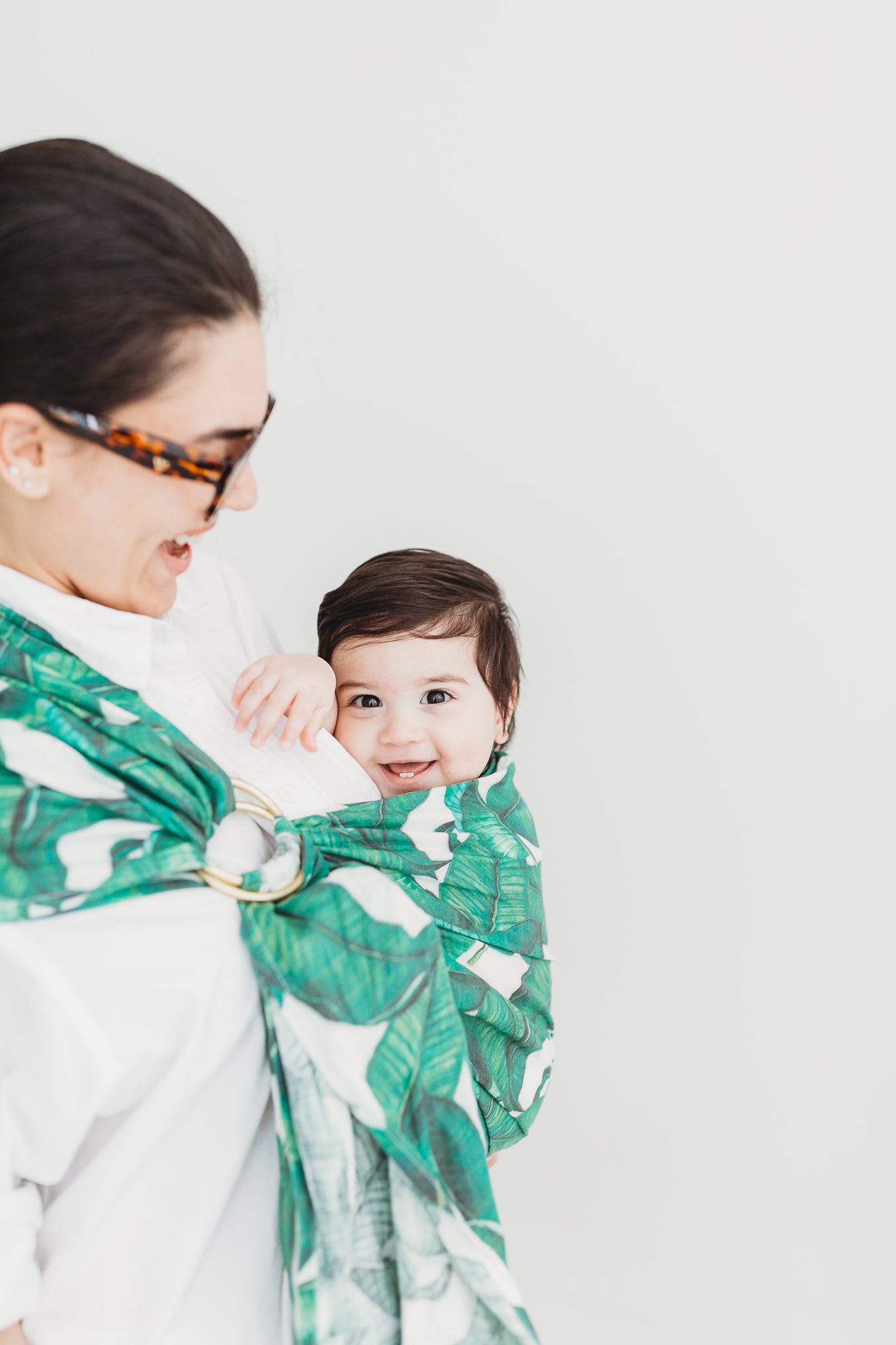 Fashionable hand made in Toronto linen ring slings. Baby carriers and baby slings made in Canada. Fun Tropical printed linen slings. Mom wearing her baby in a sling, happy baby. 